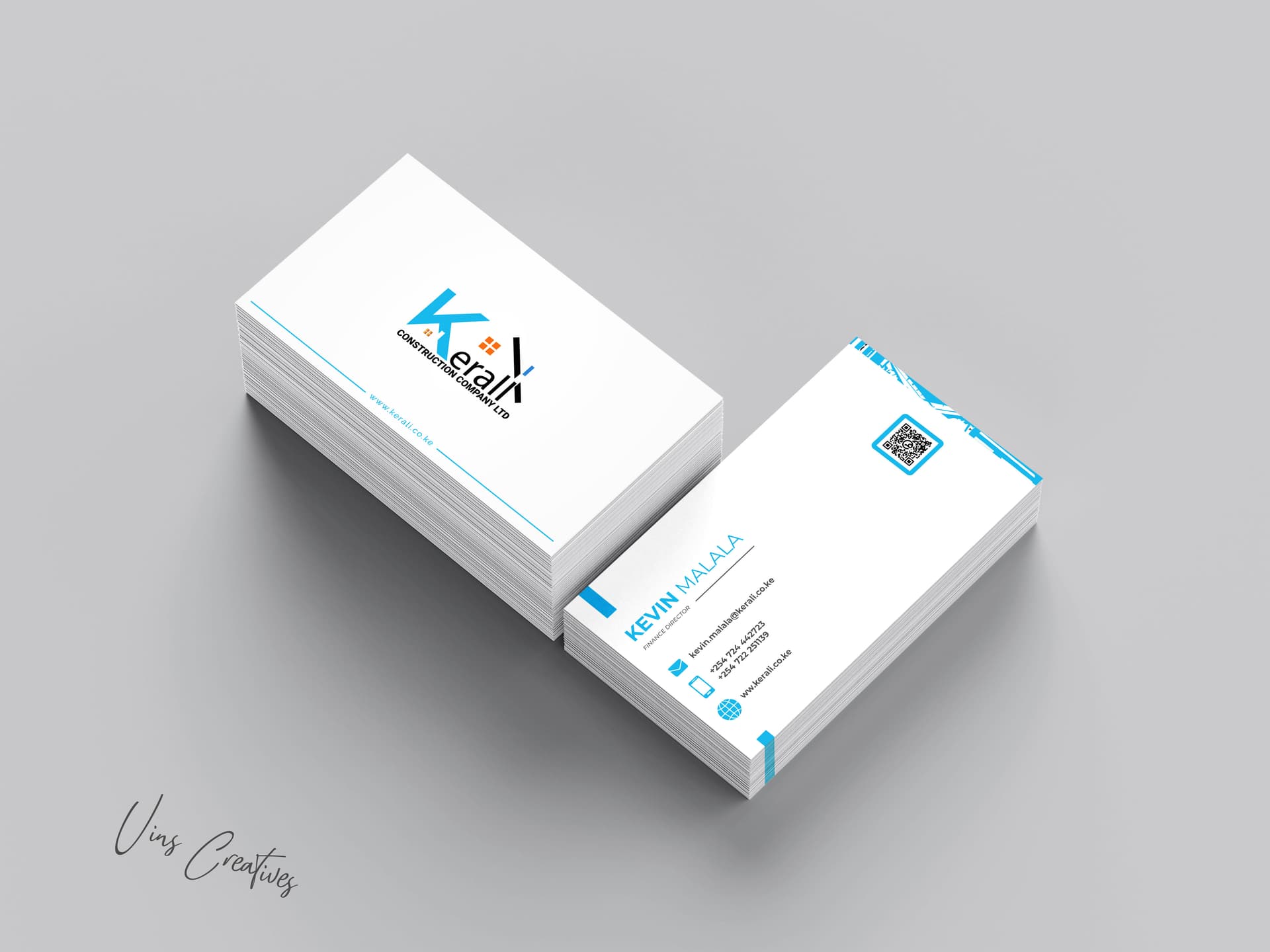 Kerali Construction business cards in a stacked mockup — the blue logo with a roofline built into the K on the front, contact details and a QR code on the back.